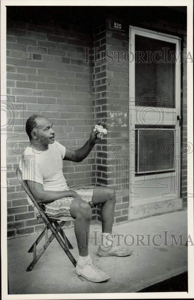 1985 Press Photo John C. Suber Sits on His Porch, Piedmont Courts Apartments, NC