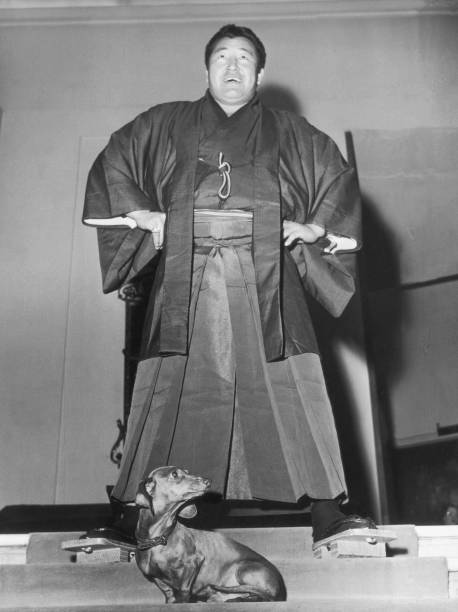 Japanese wrestling champion Rikidozan towers over a small dachs- 1956 Old Photo