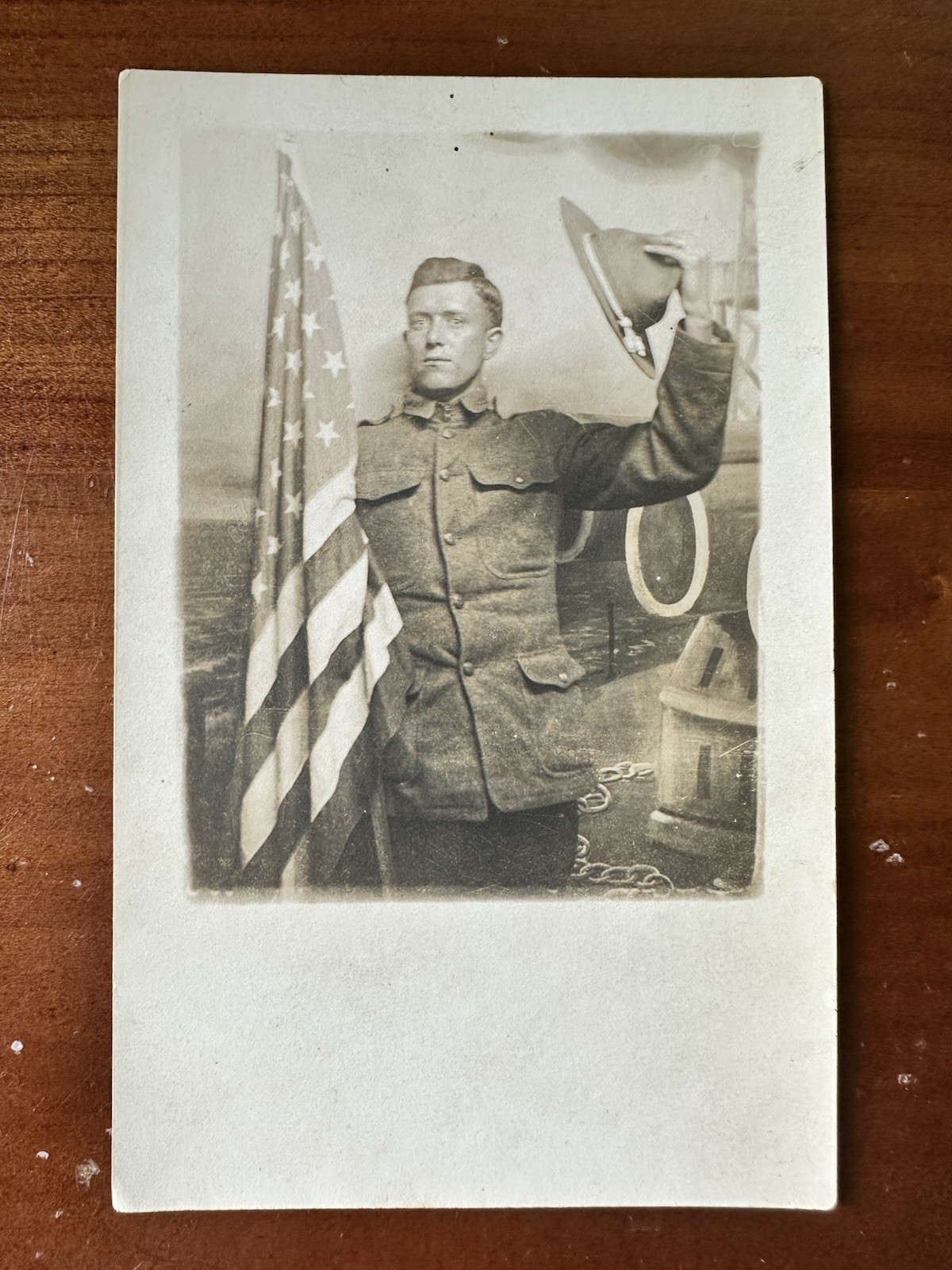 Great Shot, WWI soldier Waving Cap And Holding US flag postcard RPPC