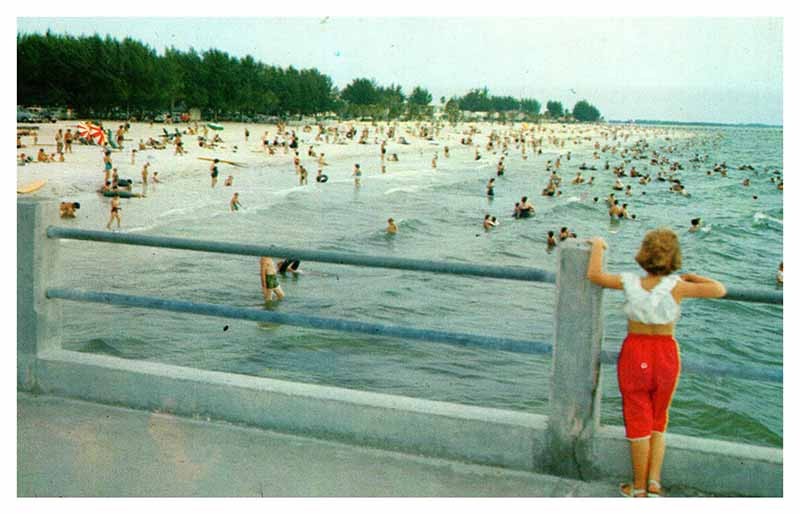Clearwater Beach FL postcard GIRL ON PIER OVERLOOKING CROWDED BEACH s/06 AT4945