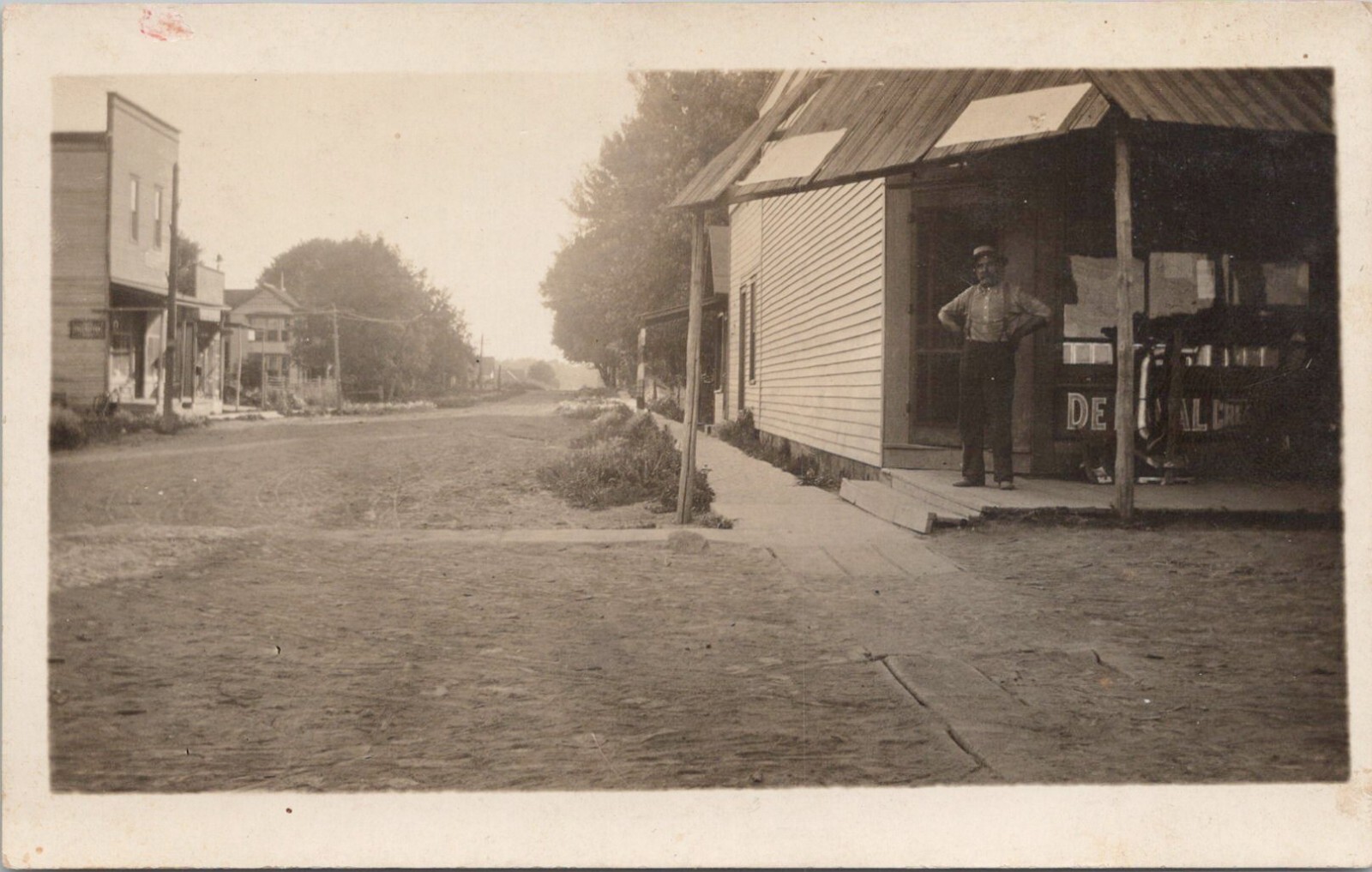 RPPC Nice Town Street Scene Man Posing at Store Front c. 1910