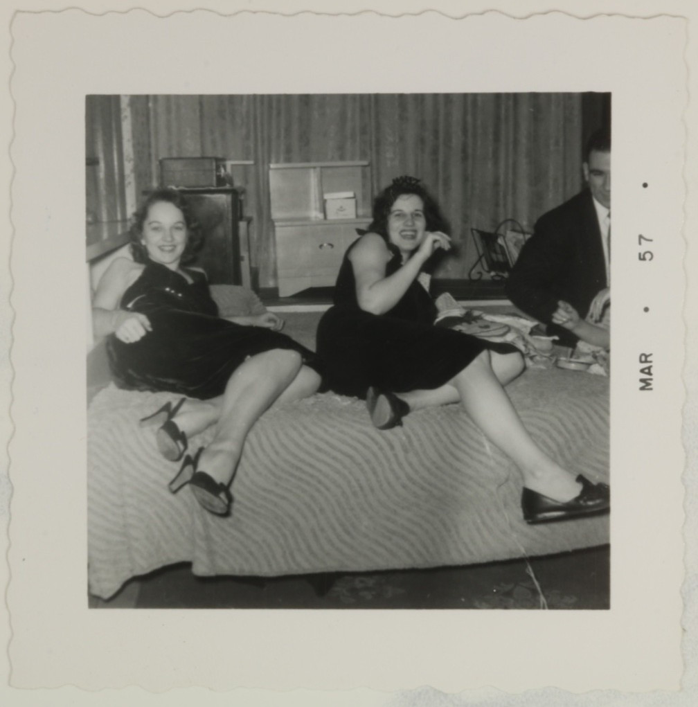 FOUND PHOTO - Two girls at a party showing off legs on bed 1950s