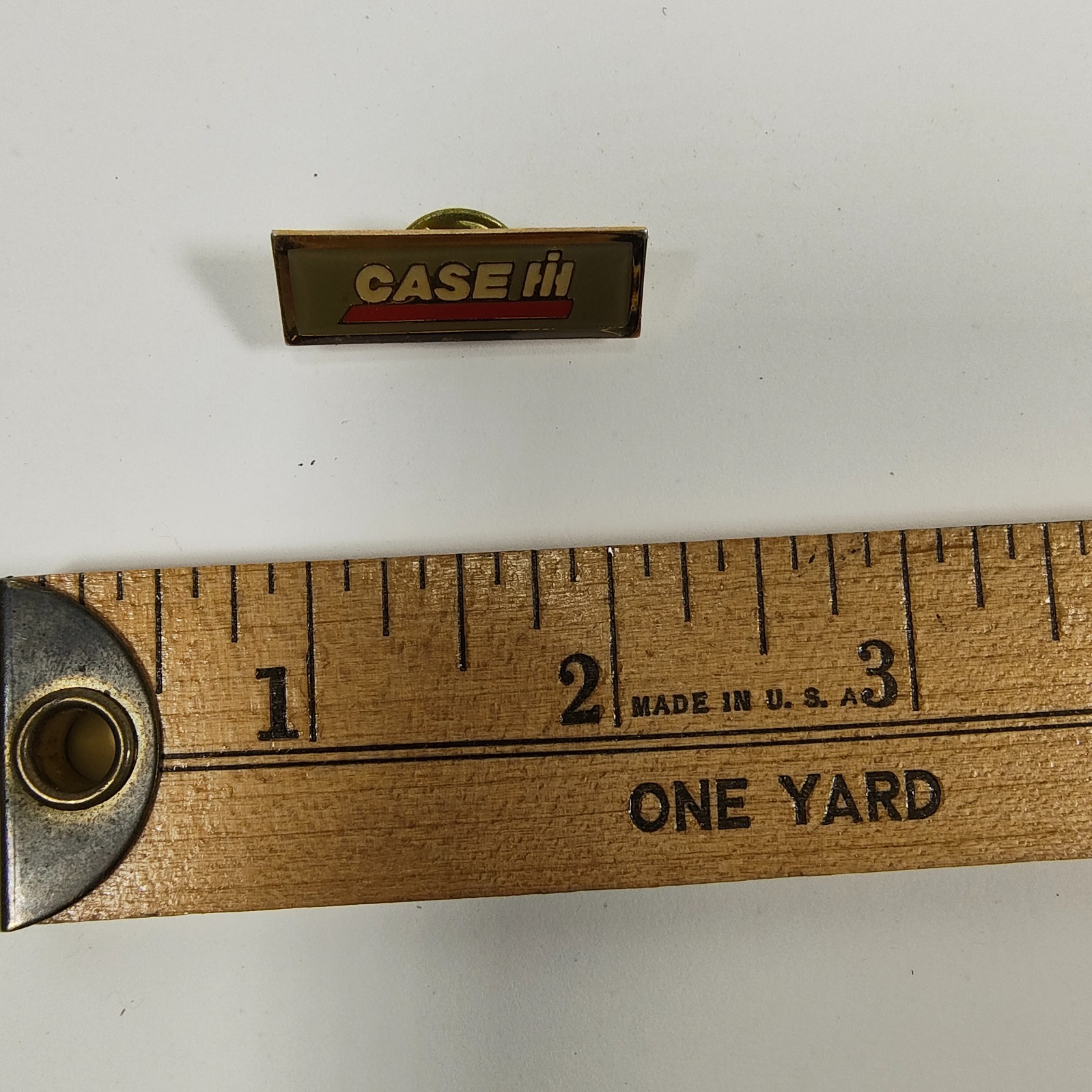 Promotional lapel pin for Case IH agricultural equipment.