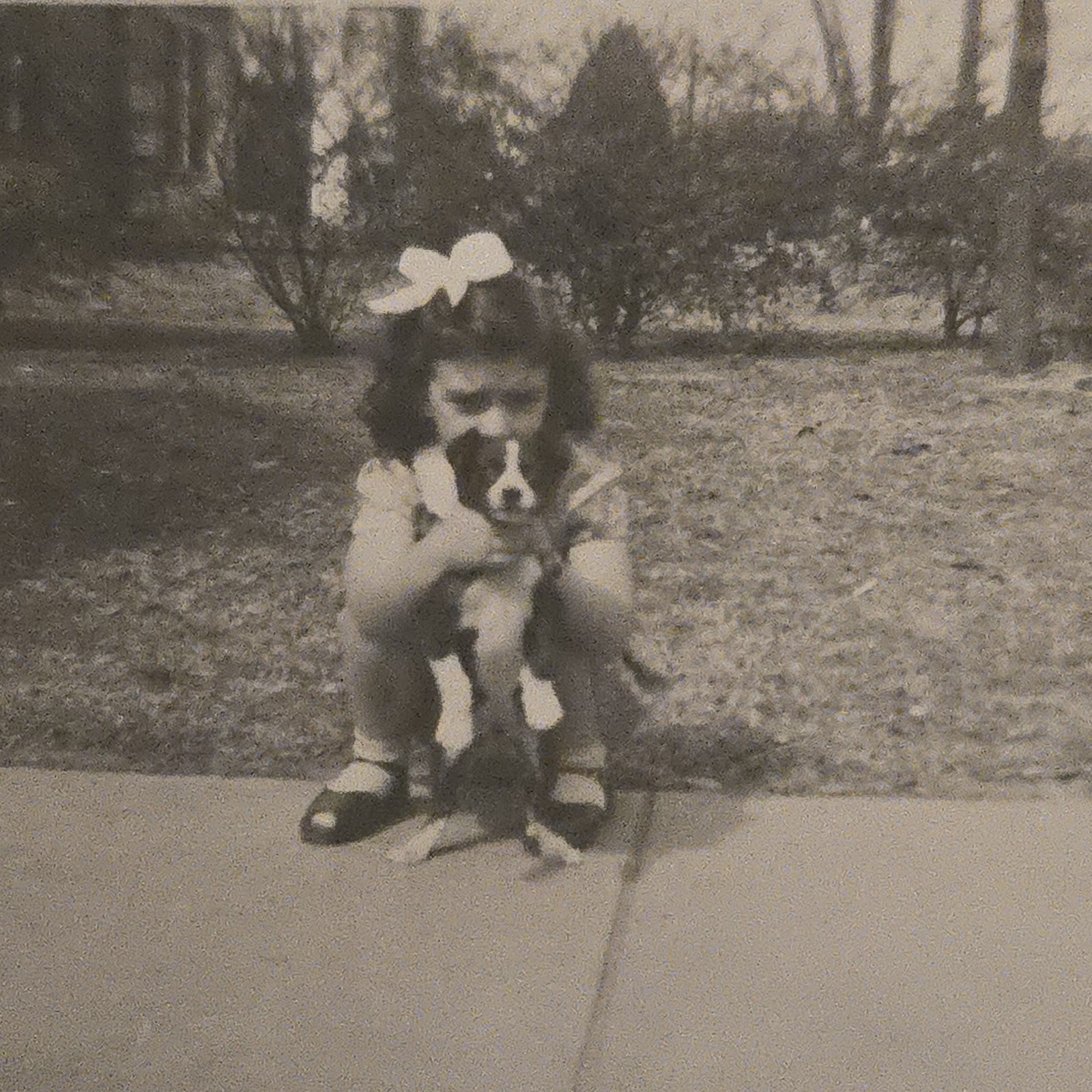 Vintage B&W Photo Snapshot of Young Girl Crouching While Holding up Puppy