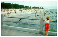 Clearwater Beach FL postcard GIRL ON PIER OVERLOOKING CROWDED BEACH s/06 AT4945 picture