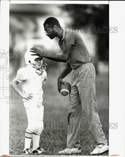 1982 Press Photo Gentleman helping young football player - lrb55409 picture