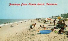 PLAYING ON BEACH SUNBATHERS GREETINGS POSTCARD DEWEY BEACH DE DELAWARE 1960s picture