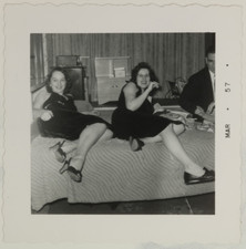FOUND PHOTO - Two girls at a party showing off legs on bed 1950s picture